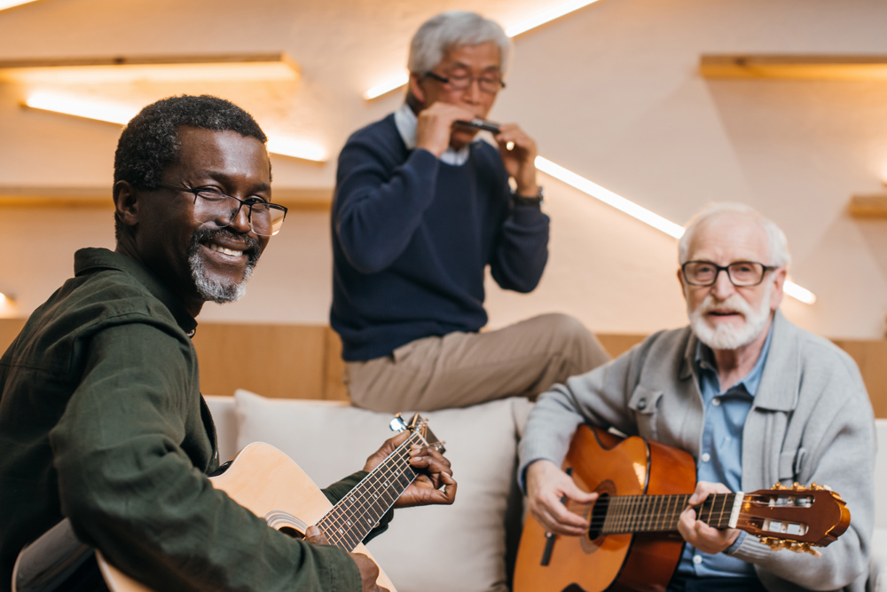 three older men playing guitars