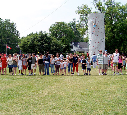 A group of people at an event with rock climbing in the background