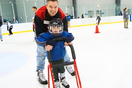 father and son skating with help from a stability walker