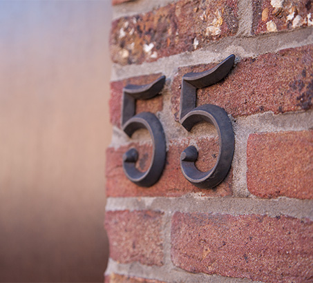 The number 55 on a brick column of a house