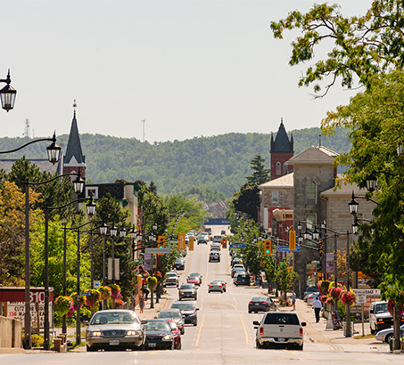 A long street with local businesses and cars