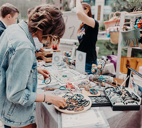 A woman looking at a table full of bracelets