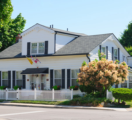 A heritage home with blue skies behind it