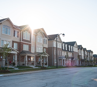 A row of houses with the sun shining above