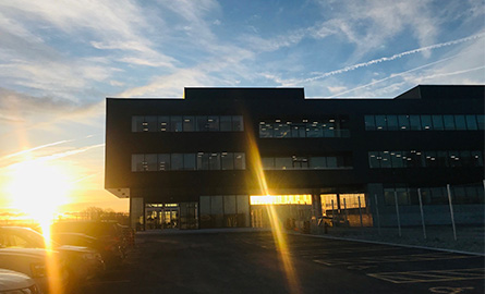 A building with the sun setting in the background