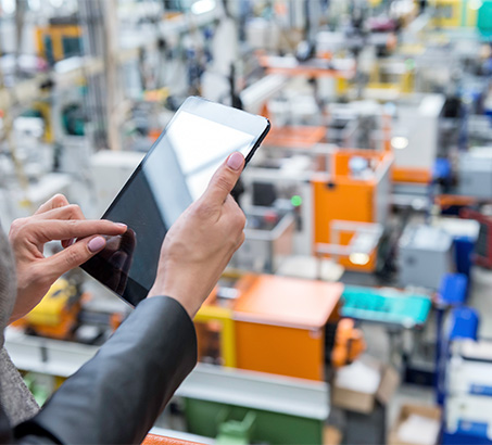 Hands holding an iPad in a warehouse