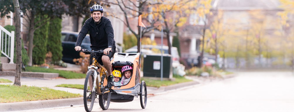 a man riding a bike with his kids 