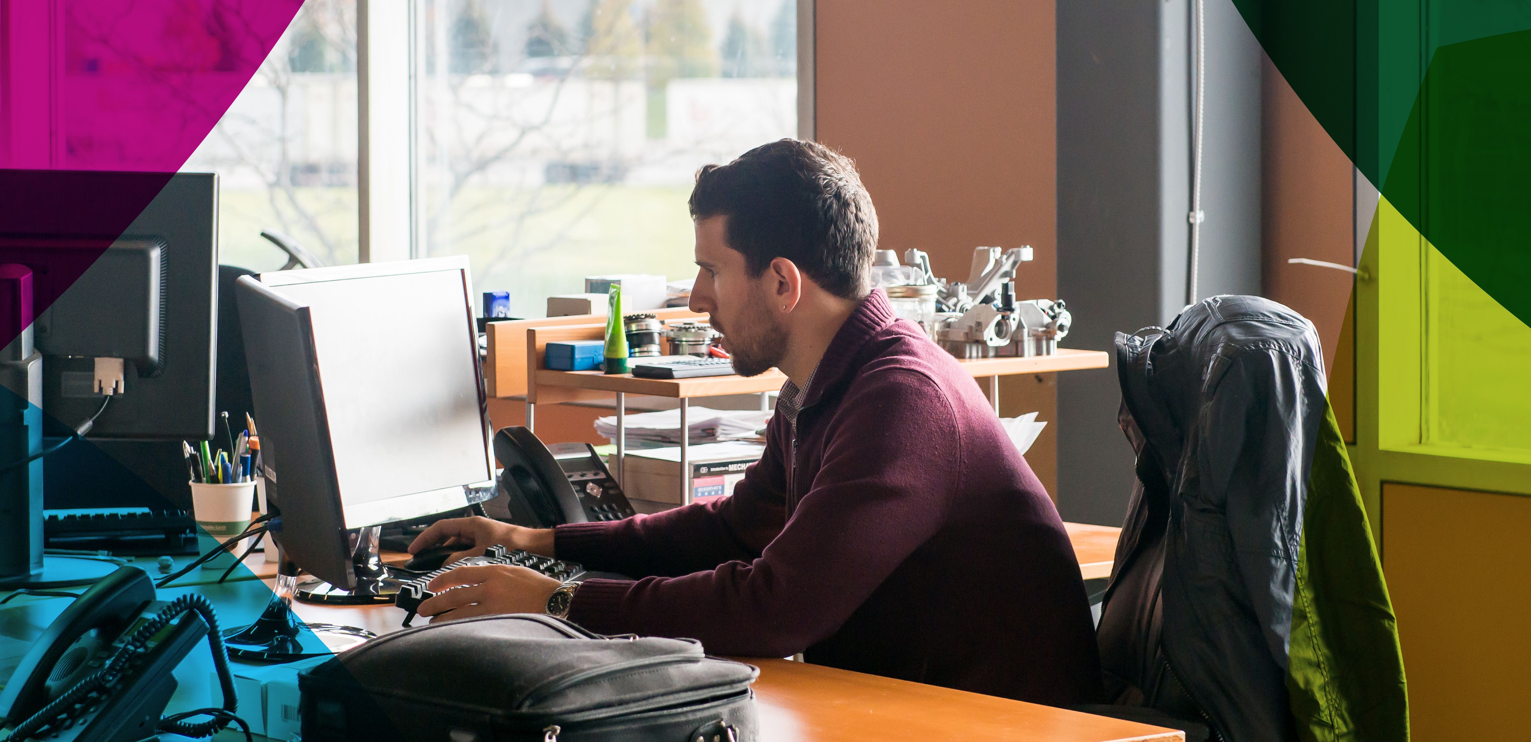 Picture of man sitting at a desk looking at computer monitor