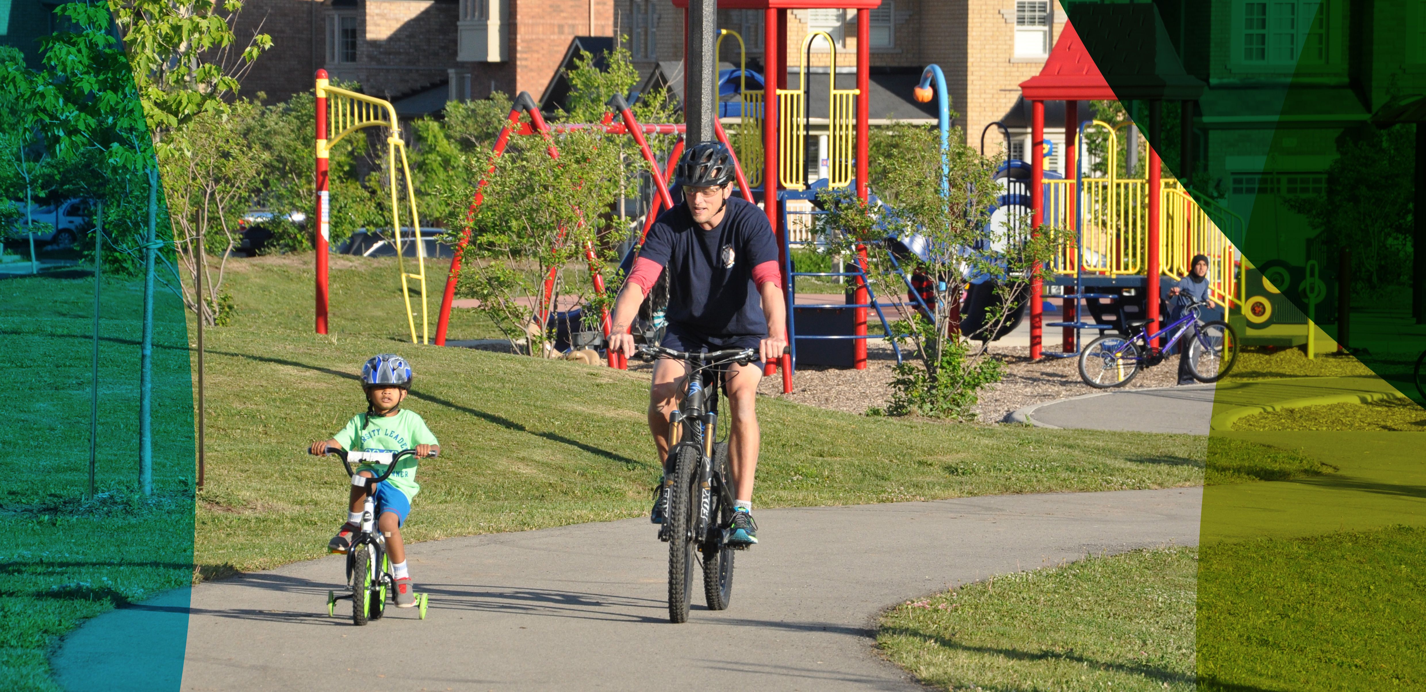 Picture of young girl and parent riding bikes in a park