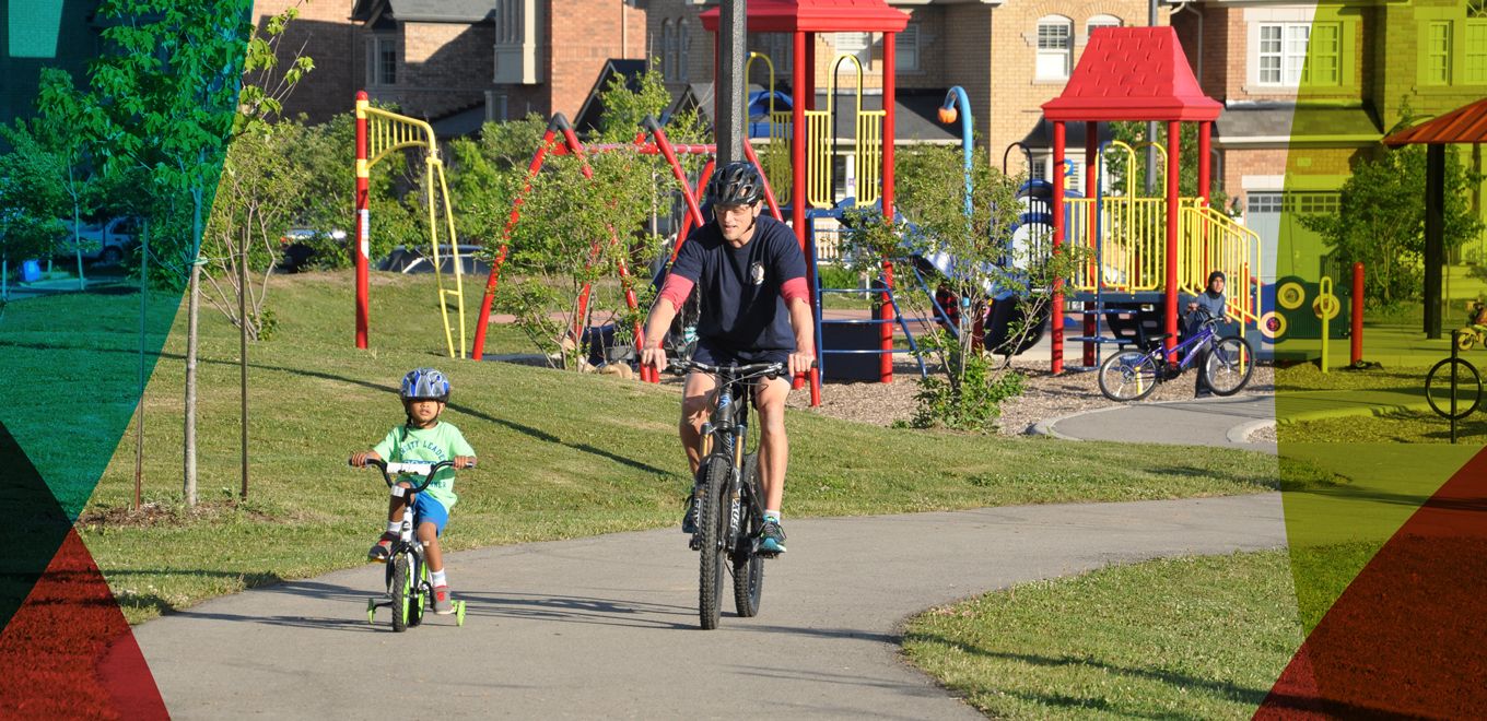 Child and father biking in park