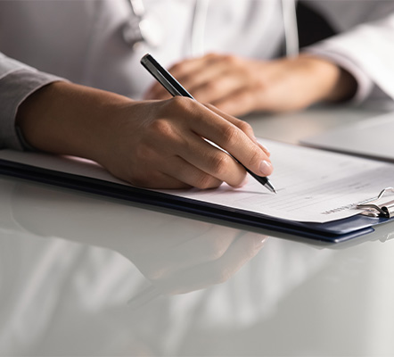 A hand holding a pen above a sheet of paper