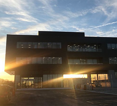 An image of a building with the sun setting behind it