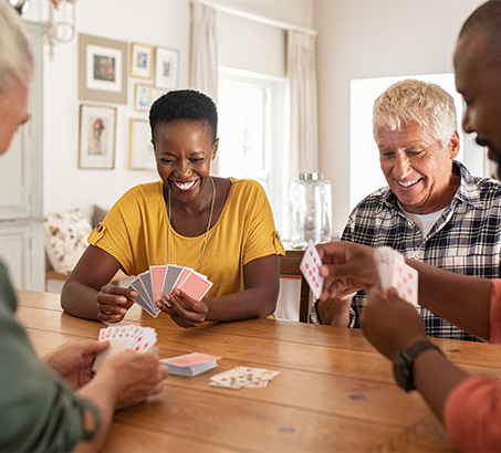 A group of seniors sitting around a table playing cards