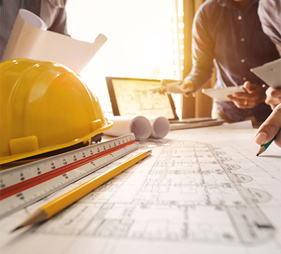 A hard hat on a table with building plans