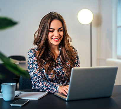 A woman sitting at a desk with a laptop