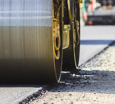 A roller flattening freshly paved asphalt 