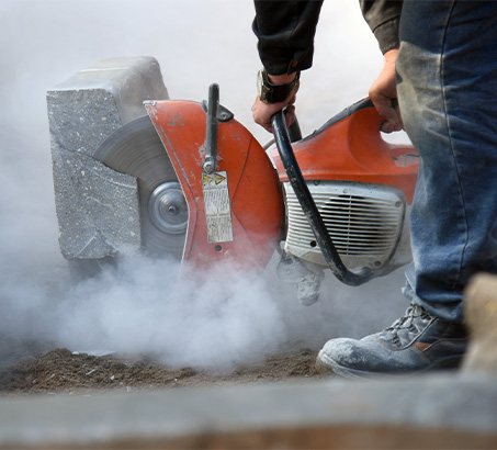 Road worker cutting a curb