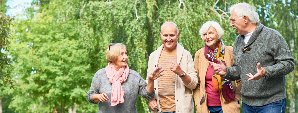 Four seniors walking and talking