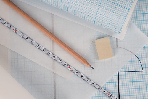 A ruler and pencil on top of blueprints