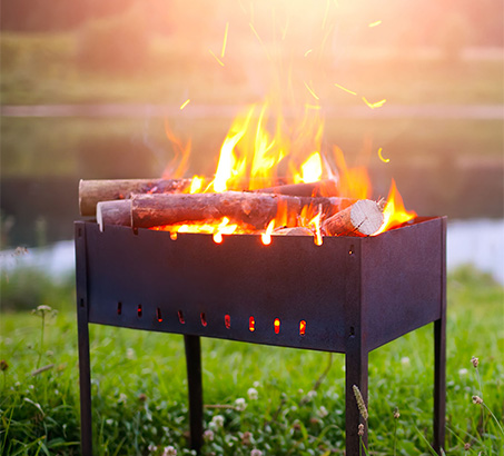 An outdoor fireplace with grass behind it