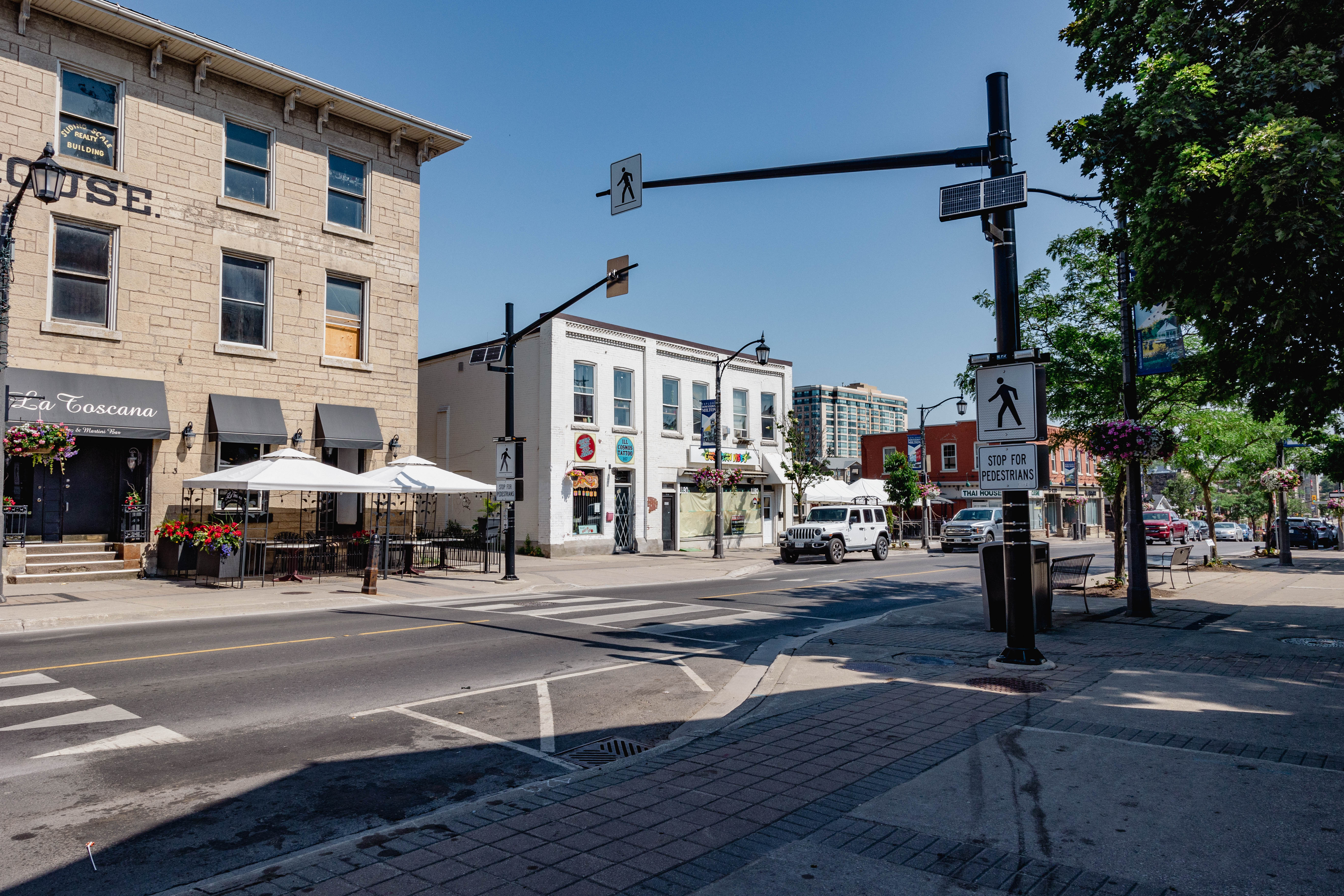 A crosswalk with overhead signs and flashing lights