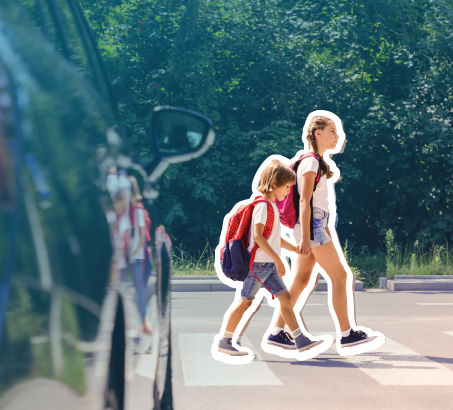 Two children safely using a crosswalk in front of a stopped car