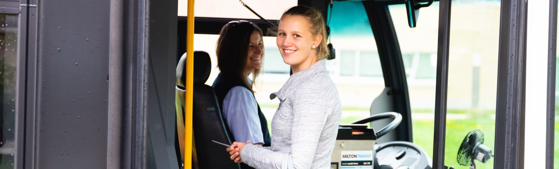 A young girl boarding a bus.