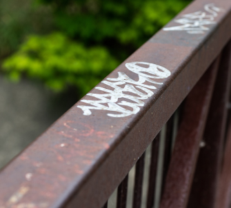 Graffiti on a railing along a trail