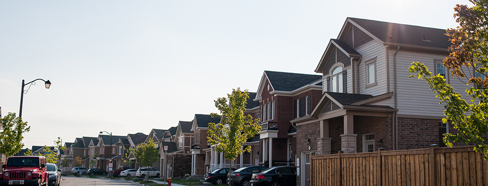 a row of houses with cars parked in the driveway