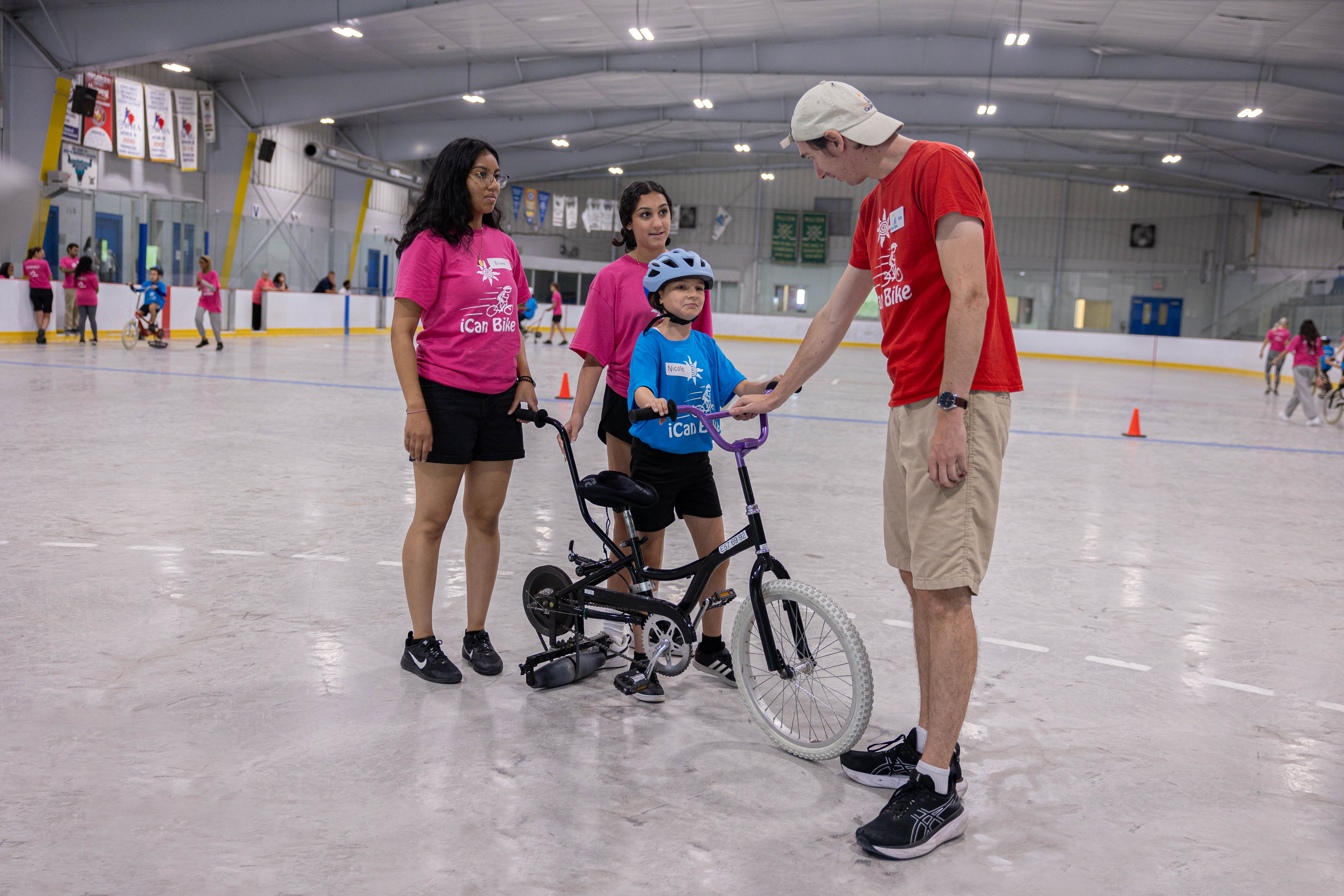 Young people helping children with disabilities to learn to ride a bike