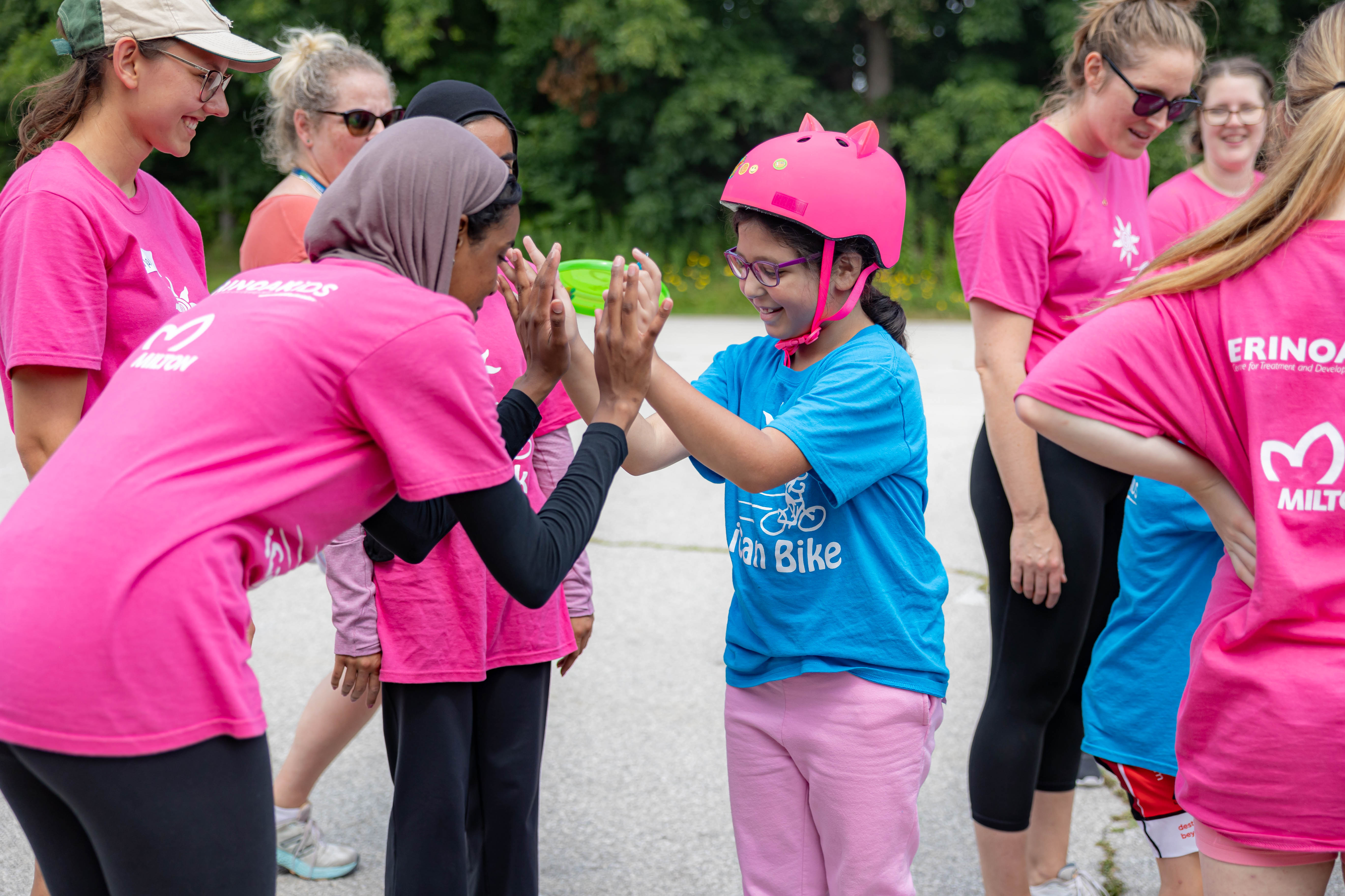 Young people helping children with disabilities to learn to ride a bike