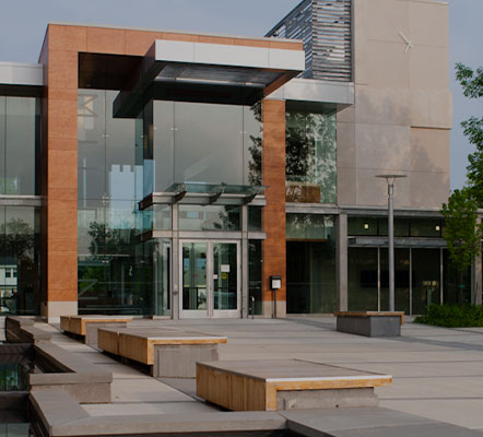 Front exterior of Milton Town Hall east building with benches and walkway lights