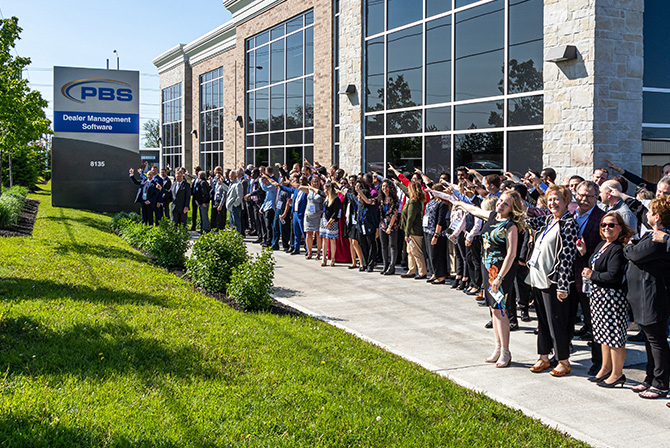 Employees pointing at PBS sign