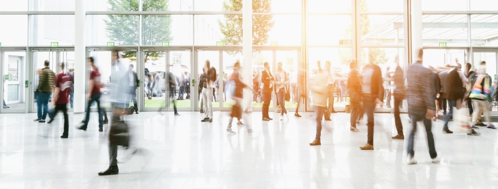 People walking inside of a glass building