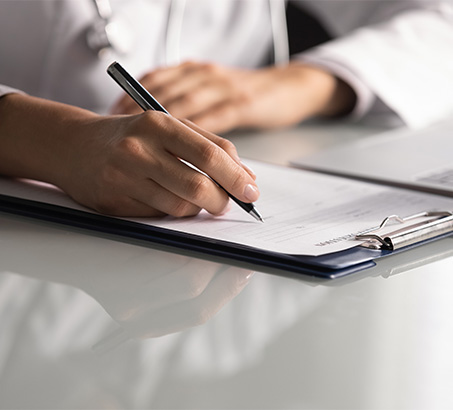 A hand holding a pen above a sheet of paper