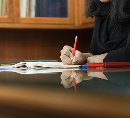 A hand holding a pencil taking notes at a table