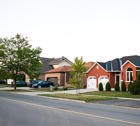 A row of houses with cars parked in the driveway