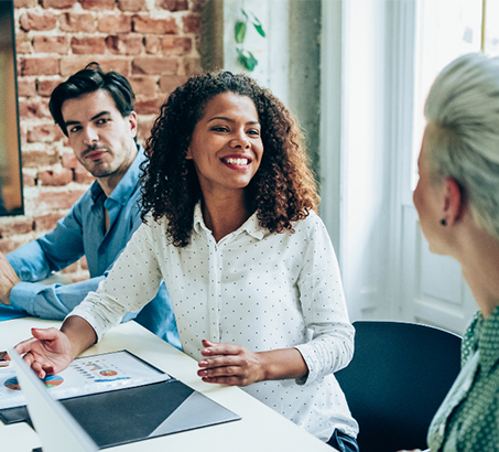 A man and two women sitting at the table conducting an audit