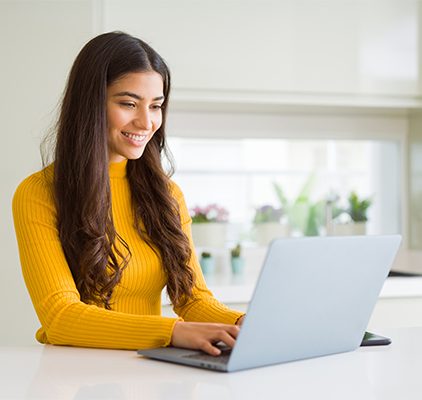 A smiling girl working on a laptop
