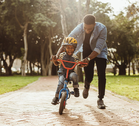 A father teaching his son how to ride a bike