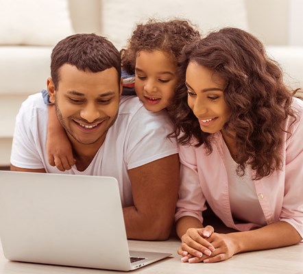 A family of three looking at a laptop screen