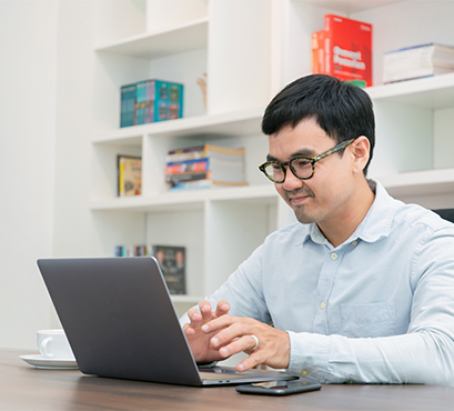 A man sitting at a table with a laptop